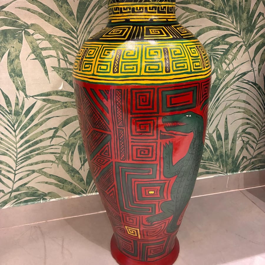 Vaso grande de cerâmica pintado de vermelho, com um jacaré verde no bojo e gregas em amarelo e preto no ombro